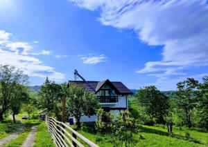a house on a green field with a fence at Deleni Retreat - Casa Sitaru in Deleni