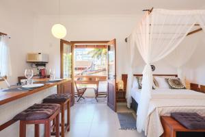 een slaapkamer met een bed, een keuken en een badkamer bij Pousada Ubatuba Flats in Ubatuba