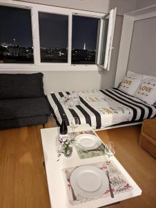 a room with a bed and a table with plates on it at Charming Studio with Eiffel View in Paris