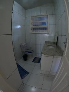 La petite salle de bains est pourvue d'un lavabo et d'un miroir. dans l'établissement Casarão hostel, à Arraial do Cabo