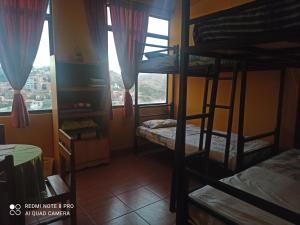 Zimmer mit 2 Etagenbetten und einem Fenster in der Unterkunft Santa Pacha in Sucre