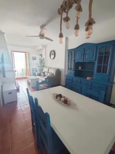 cocina con mesa blanca y armarios azules en Ventana al Albarracin, en Benamahoma