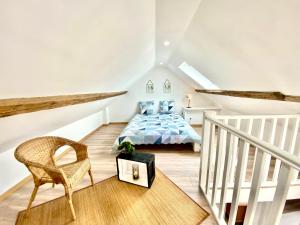 a attic bedroom with a bed and a chair at Beau duplex à deux pas du port in Le Tréport