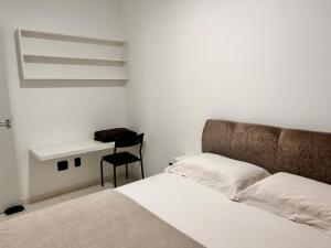 a bedroom with a bed and a desk with a chair at Apto amplo e confortável in Tijucas