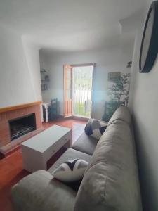 sala de estar con sofá y chimenea en Ventana al Albarracin, en Benamahoma