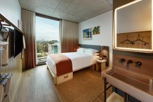 um quarto de hotel com uma cama e um lavatório em Moxy Sydney Airport em Sidney
