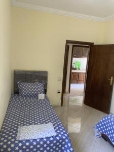 Cet appartement comprend une chambre avec deux lits et une porte menant à une cuisine. dans l'établissement kafam, à Meknès