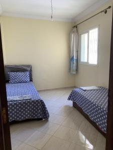 - une chambre avec 2 lits et une fenêtre dans l'établissement kafam, à Meknès