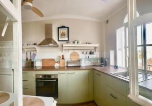 a kitchen with white cabinets and a sink at Casa Junto al Mar in La Herradura