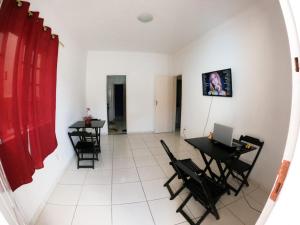 une chambre avec deux tables et des chaises et un rideau rouge dans l'établissement Casarão hostel, à Arraial do Cabo