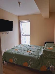 a bedroom with a bed with a television and a window at Zegarra' s Home in Lima