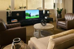 a living room with a flat screen tv and furniture at Courtyard by Marriott Long Beach Downtown in Long Beach
