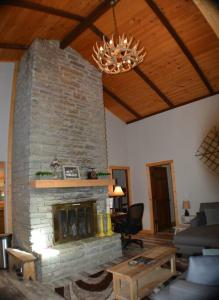 a living room with a stone fireplace and a chandelier at Cozy cabin with boosted Wi-Fi in Beech Mountain