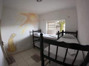 - une chambre avec 2 lits superposés et un tableau mural dans l'établissement Casarão hostel, à Arraial do Cabo