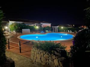 uma grande piscina num quintal à noite em Mammai's Home em Porto San Paolo