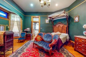 a bedroom with a canopy bed and blue chairs at Clarkson W Freeman House in Springfield