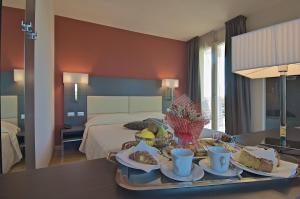 a hotel room with a tray of food on a table at Zen Hotel Versilia in Marina di Pietrasanta