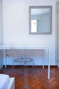 a glass table and a mirror in a room at Palazzo del Giglio in Reggio Emilia