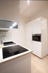 a white kitchen with a sink and a stove at Palazzo del Giglio in Reggio Emilia
