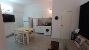 a living room with a table and a kitchen at Departamento ILLIA POP in Resistencia