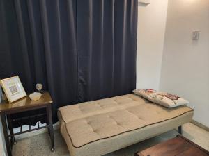 a bed in a room with black curtains and a table at Departamento ILLIA POP in Resistencia