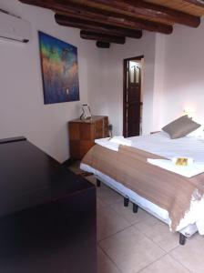 a bedroom with two beds and a painting on the wall at Hostería Aguas Coloradas in Purmamarca