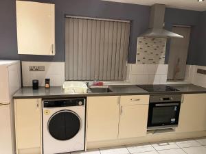 uma cozinha com uma máquina de lavar roupa e um lavatório em Work-Play Stylish, Speedwell Apartment, Free Parking em Bristol