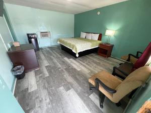 a bedroom with a bed and a desk and a chair at LAMPLIGHTER INN in Childersburg
