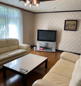 - un salon avec deux canapés et une télévision dans l'établissement Watatsumi no Yado 1981 - Vacation STAY 55945v, à Iki