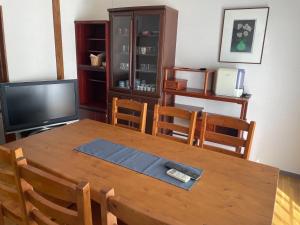 uma sala de jantar com uma mesa de madeira e uma televisão em Watatsumi no Yado 1981 - Vacation STAY 55945v em Iki