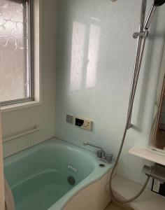 uma banheira na casa de banho com uma janela em Watatsumi no Yado 1981 - Vacation STAY 55945v em Iki