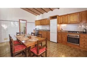 cocina con mesa, sillas y nevera en Country house with panoramic views and small pool in Inca, en Inca