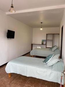 a bedroom with two beds and a tv on the wall at Monteverde Ecolodge in Monteverde Costa Rica