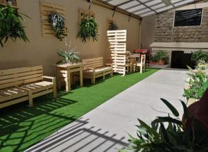a patio with benches and grass and a fireplace at EDIFICIO RENZO Apart in Tarija