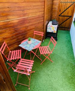un patio con 4 sillas y una mesa con una maceta en jolie maison individuelle 50 m2 ,design et climatisée, tout confort, wifi, terasse privée , 5 min plage et autoroute, stationnement gratuit en Marsella