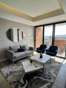危地馬拉的住宿－Luxury Apartment in zone 10，客厅配有沙发和两把椅子