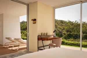 a bedroom with a view of a desk and chair at Penha Longa Resort in Sintra
