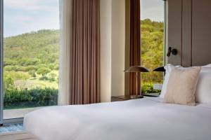 a bedroom with a large bed and a large window at Penha Longa Resort in Sintra