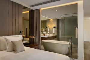 a bedroom with a tub and a bed and a bathroom at Penha Longa Resort in Sintra