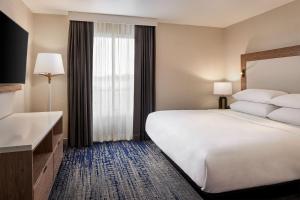 Habitación de hotel con cama grande y ventana en Sheraton Richmond Airport Hotel, en Sandston