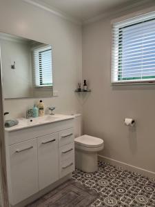 a white bathroom with a toilet and a sink at Boutique on Edinburgh in Invercargill +9 photos