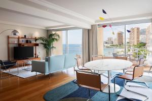 a living room with a table and chairs at Le Méridien Beach Plaza in Monte Carlo