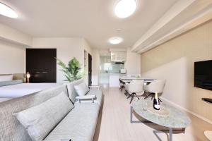 宮古島的住宿－城市生活米亞考拉凡尼爾公寓，客厅配有沙发和桌子