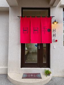 una ventana con cortinas rojas frente a un edificio en 日日和 en Tainan