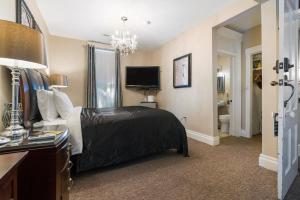 una camera d'albergo con letto e TV di Historic Branson Hotel - Haven Suite with Queen Bed - Downtown - FREE TICKETS INCLUDED a Branson