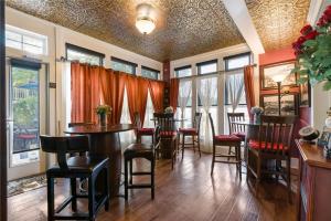 un comedor con mesas, sillas y ventanas en Historic Branson Hotel - Haven Suite with Queen Bed - Downtown - FREE TICKETS INCLUDED en Branson