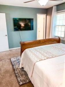 a bedroom with a bed and a painting on the wall at Beautiful 3-bedroom home next to Ft Bragg in Fayetteville
