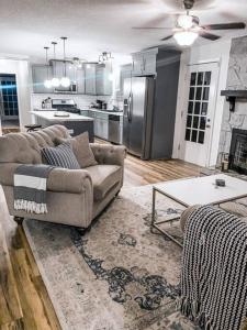 a living room with a couch and a kitchen at Beautiful 3-bedroom home next to Ft Bragg in Fayetteville