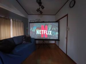 a living room with a tv and a blue couch at BISK PARK TOKYO - 4LDK Spacious House - Easy Access to Asakusa, Skytree area & Airport in Tokyo