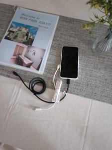 a cell phone is hooked up to a book at BISK PARK TOKYO - 4LDK Spacious House - Easy Access to Asakusa, Skytree area & Airport in Tokyo